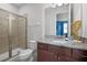 Well-lit bathroom with glass enclosed shower and granite vanity at 7739 Graben St, Kissimmee, FL 34747