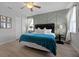 Bedroom with textured accent wall, ceiling fan, and a bed with tufted headboard and blue coverlet at 7739 Graben St, Kissimmee, FL 34747