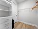 Well-organized walk-in closet with ample shelving and hanging space and wood laminate floors at 7739 Graben St, Kissimmee, FL 34747