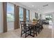 Bright dining room with large windows, a long wooden table with seating for ten, and neutral decor at 7739 Graben St, Kissimmee, FL 34747