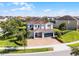 Beautiful aerial view of a two-story home with lush landscaping and a brick driveway at 7739 Graben St, Kissimmee, FL 34747