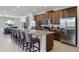 Open kitchen featuring granite counters, stainless steel appliances, and an island with barstool seating at 7739 Graben St, Kissimmee, FL 34747