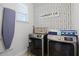 Well-organized laundry room featuring modern appliances and stylish patterned wallpaper at 7739 Graben St, Kissimmee, FL 34747