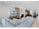 Cozy living room with a large sectional sofa, media center, and open access to the kitchen and dining area at 7739 Graben St, Kissimmee, FL 34747
