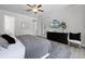 Bright bedroom featuring luxury vinyl floors, ceiling fan, and large TV screen at 7739 Graben St, Kissimmee, FL 34747