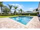 Backyard oasis featuring a swimming pool, spa, lush landscaping, and lounge chairs for relaxation at 7739 Graben St, Kissimmee, FL 34747