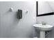 Bathroom features a pedestal sink, wall mirror, and light blue walls at 8187 Roseville Rd, Davenport, FL 33896