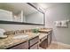Bathroom with double vanity featuring granite countertops and a large mirror with bright lighting at 8187 Roseville Rd, Davenport, FL 33896