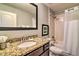 Bathroom featuring a granite countertop, dark wood cabinetry, and a shower-tub combination at 8187 Roseville Rd, Davenport, FL 33896