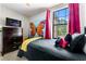 bedroom featuring a butterfly mural, red curtains, and plush pillows at 8187 Roseville Rd, Davenport, FL 33896