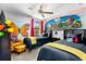 bedroom featuring twin beds, unique mural, ceiling fan, and playful decorations at 8187 Roseville Rd, Davenport, FL 33896