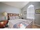 Comfortable bedroom with vaulted ceilings, arched window, and side tables at 8187 Roseville Rd, Davenport, FL 33896