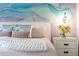 Bright bedroom features a pastel mural, plush pillows, and stylish bedside table with fresh flowers at 8187 Roseville Rd, Davenport, FL 33896