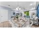 Open dining area featuring a modern chandelier, a statement wall, and a living space view at 8187 Roseville Rd, Davenport, FL 33896