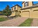 Two-story home with a beautiful brick driveway and well-maintained landscaping on a sunny day at 8187 Roseville Rd, Davenport, FL 33896