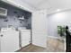 Upstairs laundry room features washer, dryer, and shelving for storage at 8187 Roseville Rd, Davenport, FL 33896