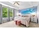 Serene main bedroom with large windows, a tray ceiling, and a decorative accent wall at 8187 Roseville Rd, Davenport, FL 33896