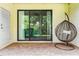Relaxing patio space with a hanging chair and sliding glass doors offering serene views of the lush greenery at 8187 Roseville Rd, Davenport, FL 33896