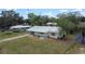 Wide aerial shot showcasing the charming single-story home, metal roof, and surrounding landscape at 88 E Charlotte Ave, Eustis, FL 32726