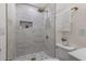 Sleek bathroom with marble tile shower, gold fixtures, a shower niche, and pebble shower floor at 88 E Charlotte Ave, Eustis, FL 32726