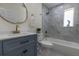 Bright bathroom featuring a blue vanity, modern fixtures, and a tub with a marble-tiled surround at 88 E Charlotte Ave, Eustis, FL 32726