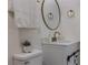 Elegant bathroom with white vanity, gold fixtures, round mirror, and decorative accents at 88 E Charlotte Ave, Eustis, FL 32726