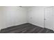This simple bedroom has 3 doors and grey wood-look floors at 88 E Charlotte Ave, Eustis, FL 32726