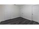 A bedroom featuring wood-look flooring and three closets/doors at 88 E Charlotte Ave, Eustis, FL 32726