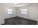Bedroom with dark wood-look floors and natural light from two windows at 88 E Charlotte Ave, Eustis, FL 32726