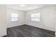 This is a simple bedroom with grey wood-look flooring and two windows at 88 E Charlotte Ave, Eustis, FL 32726