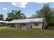 Charming single-story home featuring a metal roof, pale yellow exterior and a well-maintained lawn at 88 E Charlotte Ave, Eustis, FL 32726