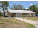 Inviting single-story home featuring a metal roof, covered front porch, and charming blue doors at 88 E Charlotte Ave, Eustis, FL 32726