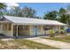 Beautiful home featuring a metal roof, pale yellow exterior and a long driveway at 88 E Charlotte Ave, Eustis, FL 32726