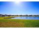 Picturesque lake view with beautiful green lawns and single Gathering homes in the background at 8933 Hinsdale Heights Dr, Polk City, FL 33868