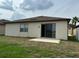 Backyard view with patio and sliding glass doors, leading to a grassy yard at 8933 Hinsdale Heights Dr, Polk City, FL 33868