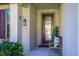 Inviting front porch with decorative door, lantern, and comfortable seating, creating a warm welcome at 8933 Hinsdale Heights Dr, Polk City, FL 33868