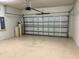 Spacious garage with speckled flooring, overhead door and water equipment at 8933 Hinsdale Heights Dr, Polk City, FL 33868