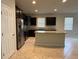 Bright open kitchen features a center island, stainless steel appliances, dark cabinets, and tile flooring at 8933 Hinsdale Heights Dr, Polk City, FL 33868