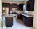 Modern kitchen features stainless steel appliances, dark cabinetry, and granite countertops at 8933 Hinsdale Heights Dr, Polk City, FL 33868