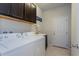 Functional laundry room with modern washer, dryer, sink and storage cabinets at 8933 Hinsdale Heights Dr, Polk City, FL 33868