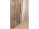 Neutral tile shower with glass door and tan tile floor outside the shower at 8933 Hinsdale Heights Dr, Polk City, FL 33868