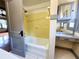 This bathroom includes a tub, vanity and yellow tiling at 900 Carlton Ave, Lake Wales, FL 33853