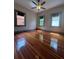 This bedroom has hardwood floors, three windows and a ceiling fan at 900 Carlton Ave, Lake Wales, FL 33853