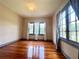 A bright bedroom with hardwood floors and a large window with light grey trim and curtains at 900 Carlton Ave, Lake Wales, FL 33853