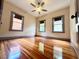 Spacious bedroom with hardwood floors and a ceiling fan, brightened by three windows at 900 Carlton Ave, Lake Wales, FL 33853