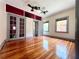 Bedroom featuring hardwood flooring, 2 ceiling fans, and french doors leading to a parlor at 900 Carlton Ave, Lake Wales, FL 33853