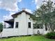 Rear view of a stucco house with a distinctive chimney, windows, and a screened porch, offering a glimpse of comfortable living at 900 Carlton Ave, Lake Wales, FL 33853