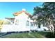 Stucco home with terra cotta roof, screened porch, and mature landscaping adding character and charm at 900 Carlton Ave, Lake Wales, FL 33853