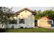 This house has a stucco exterior, a tile roof, a detached garage, and mature trees at 900 Carlton Ave, Lake Wales, FL 33853