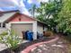 A detached garage with a brick walkway surrounded by lush landscaping, providing a charming curb appeal at 900 Carlton Ave, Lake Wales, FL 33853